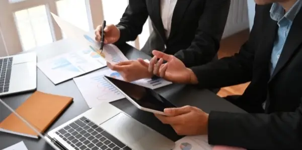 Two People Working With Business Growth Documents - Traditional Marketing Methods Cost Business Growth Toltech Digital - Outsourced Web Design